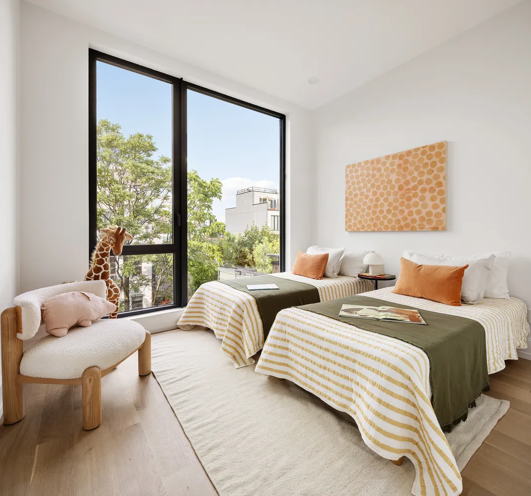 a bedroom with two beds and a large window