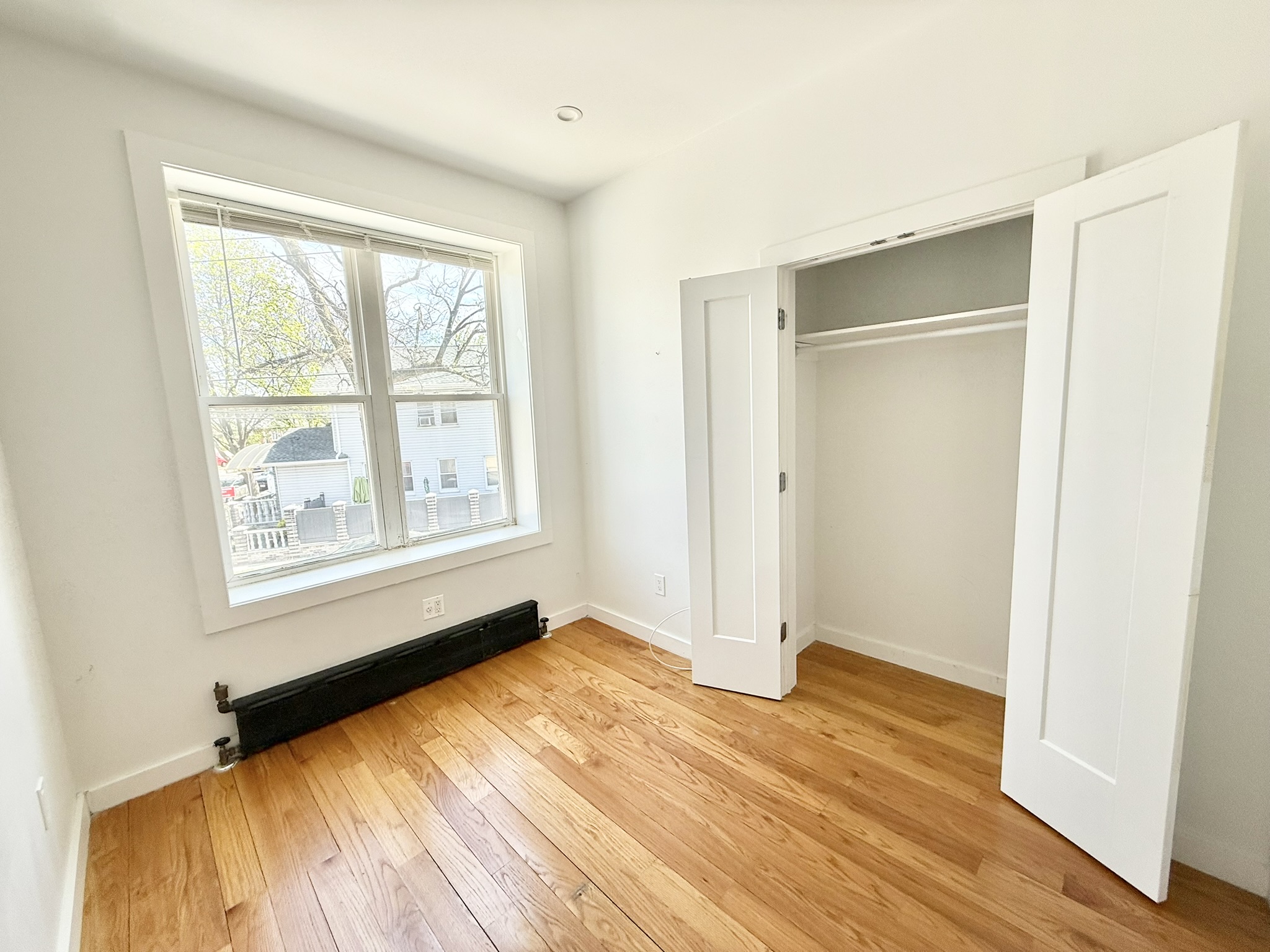 2013 Flatbush Avenue, Unit 2R Brooklyn, NY 11234 - Photo 5 of 11 a view of an empty room with wooden floor and a window