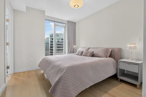 a large bed sitting in a bedroom next to a window