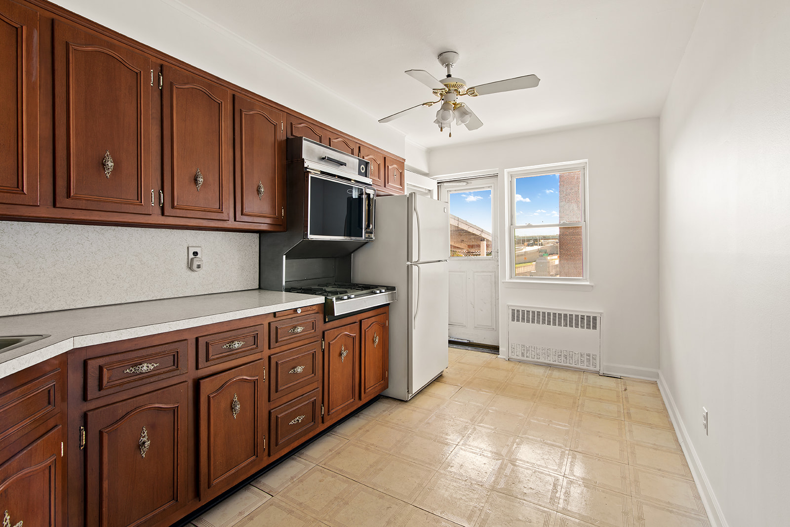 572 92nd Street Brooklyn, NY 11209 - Photo 16 of 20 a kitchen with stainless steel appliances granite countertop a refrigerator a stove top oven with white cabinets
