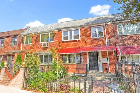 front view of a brick house with a large windows
