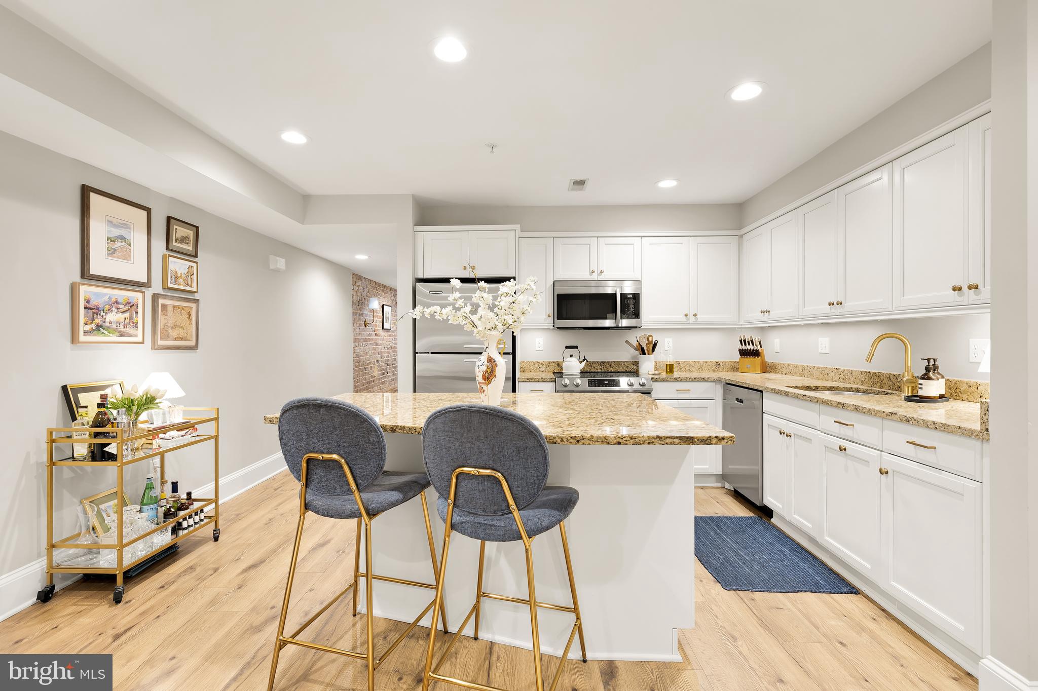 1354 Kenyon Street Northwest, Unit G Washington, DC 20010 - Photo 10 of 37 a kitchen with stainless steel appliances kitchen island granite countertop a refrigerator a stove a sink dishwasher and white cabinets with wooden floor