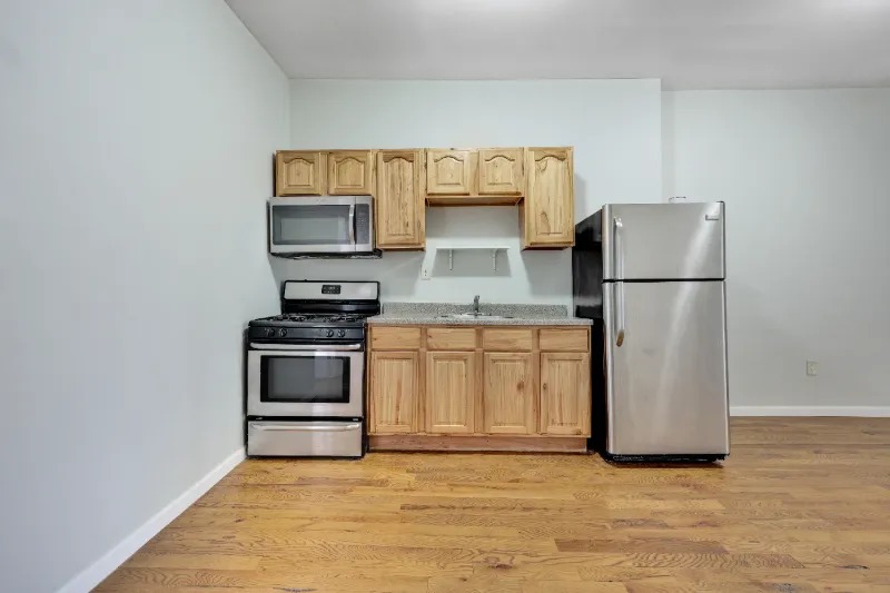 255 Covert Street Brooklyn, NY 11207 - Photo 6 of 18 a kitchen with a refrigerator and a stove