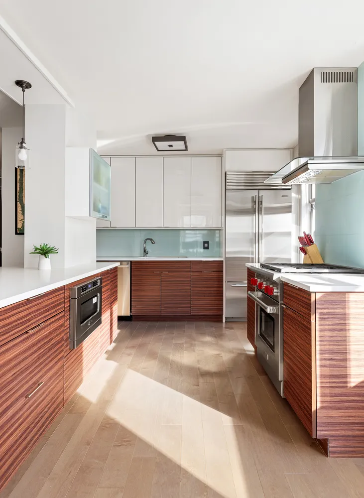 a kitchen with stainless steel appliances kitchen island granite countertop a stove a sink and a refrigerator