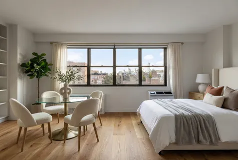 a bedroom with a bed and a large window