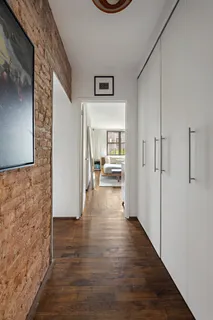 a view of a hallway view with wooden floor and a living room
