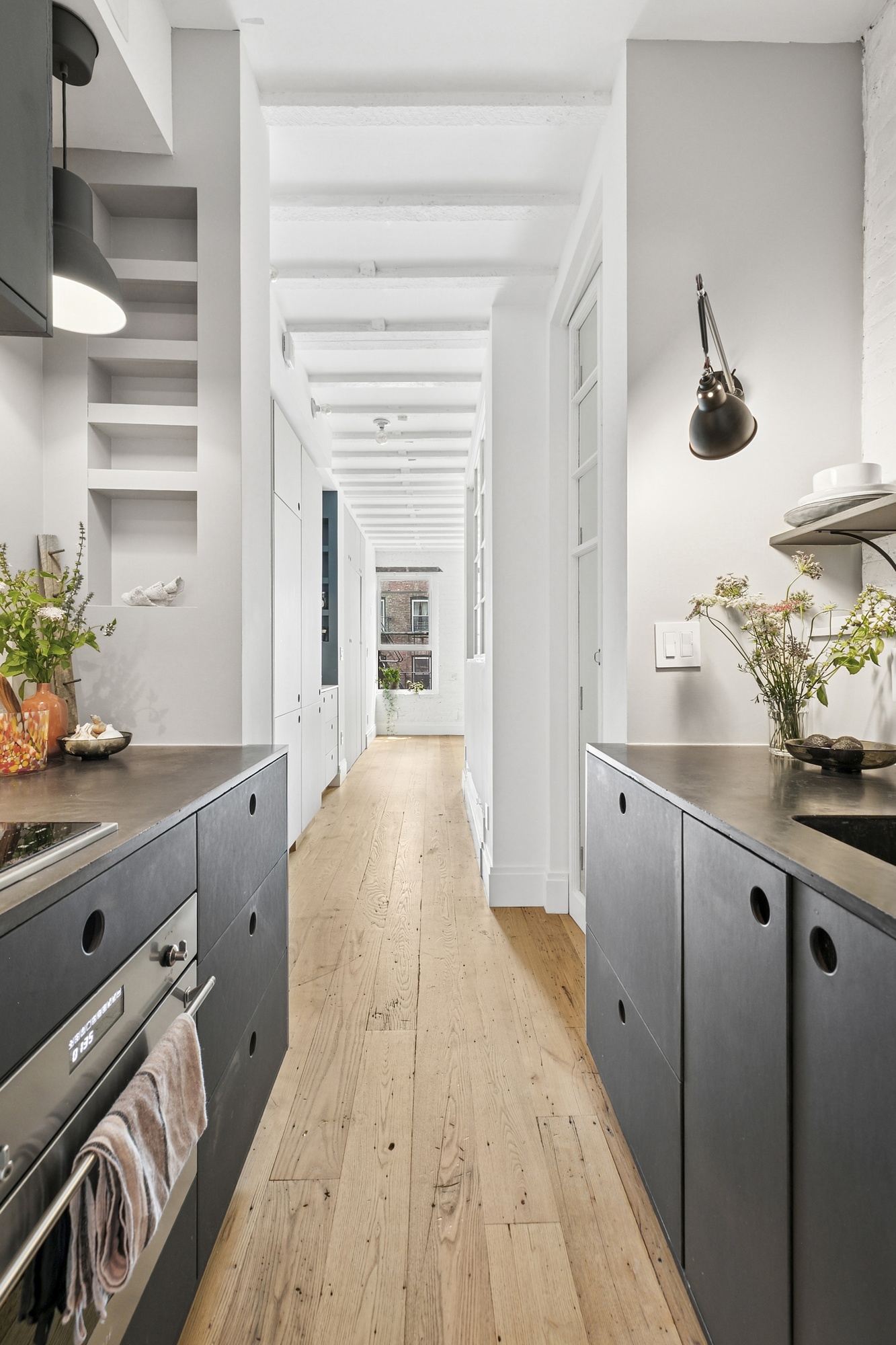 138 West 10th Street, Unit 2RW Manhattan, NY 10014 - Photo 5 of 10 a kitchen with granite countertop white cabinets and wooden floor