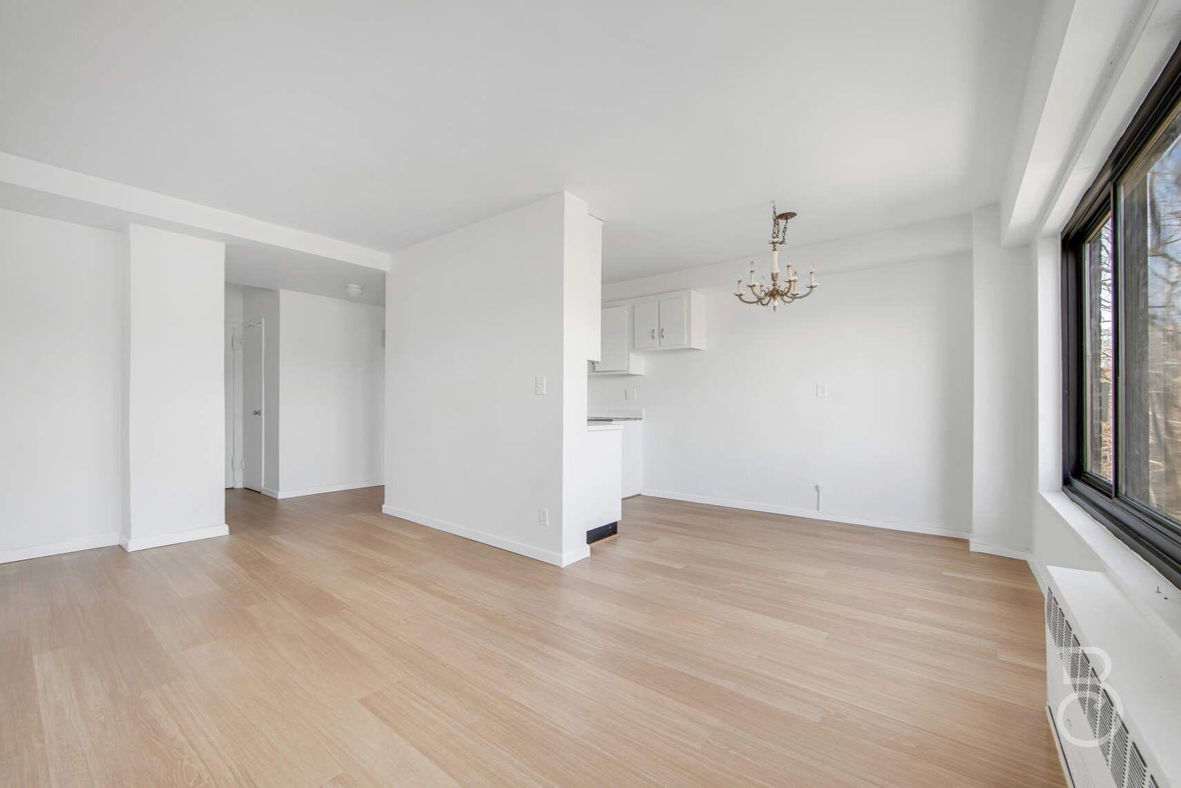 33-65 14th Street, Unit 5D Queens, NY 11106 - Photo 2 of 11 wooden floor in an empty room with a window