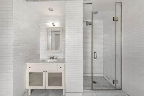 a bathroom with a sink a mirror and shower