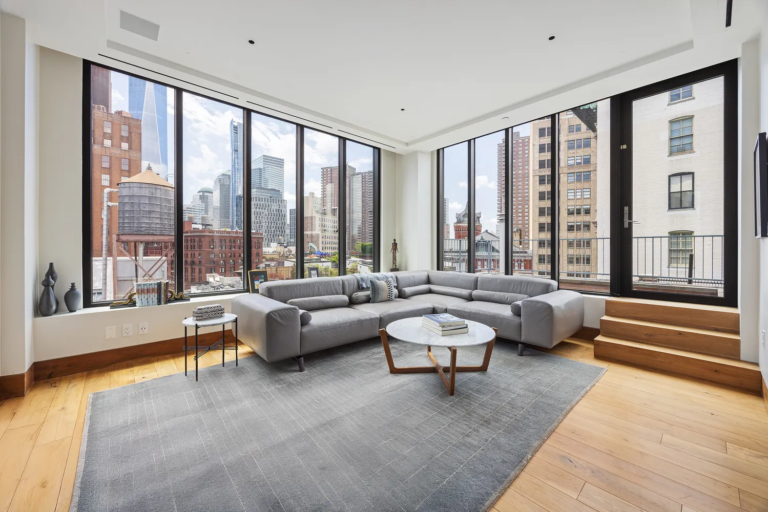 a living room with furniture and floor to ceiling windows