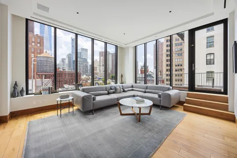 a living room with furniture and floor to ceiling windows