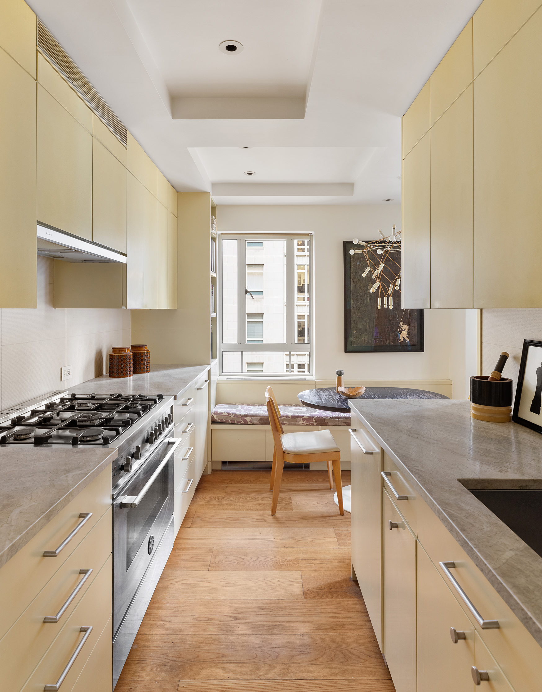 25 Central Park West, Unit 11C Manhattan, NY 10023 - Photo 4 of 17 a kitchen with a stove a sink and a wooden cabinets