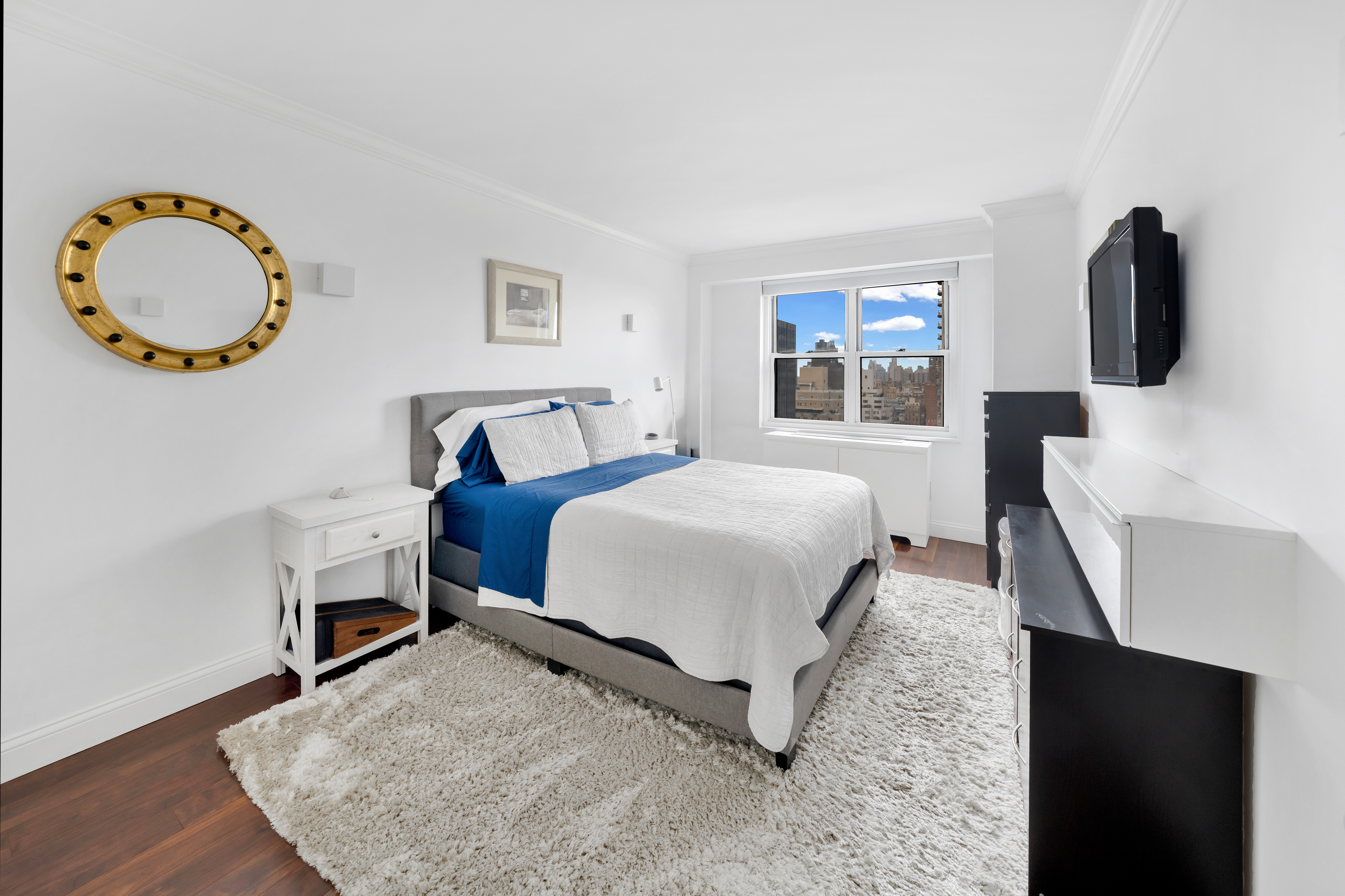 400 East 54th Street, Unit 26D Manhattan, NY 10022 - Photo 5 of 12 a bedroom with a bed and a flat screen tv