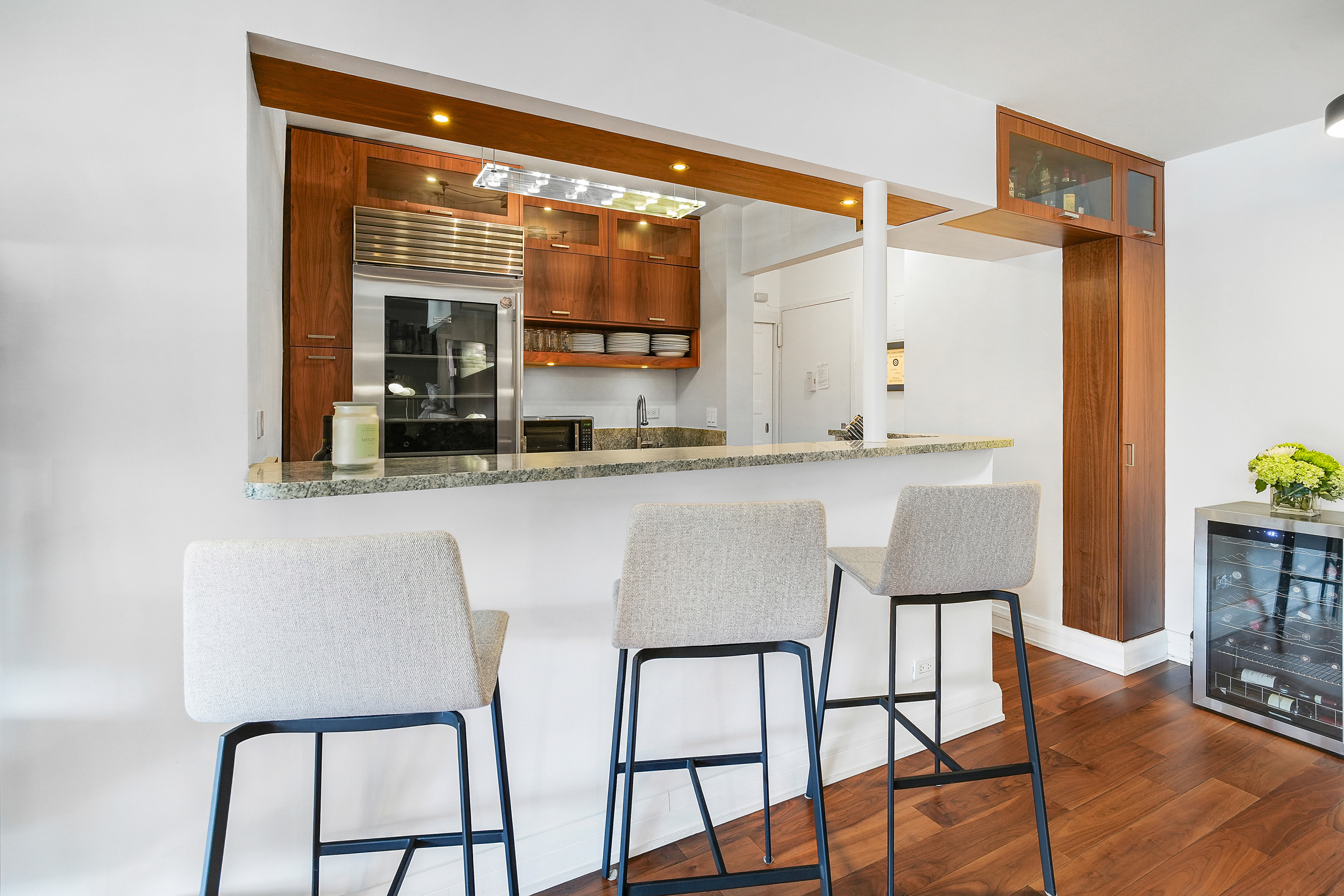 220 East 54th Street, Unit 11H Manhattan, NY 10022 - Photo 6 of 13 a kitchen with a table chairs refrigerator and sink