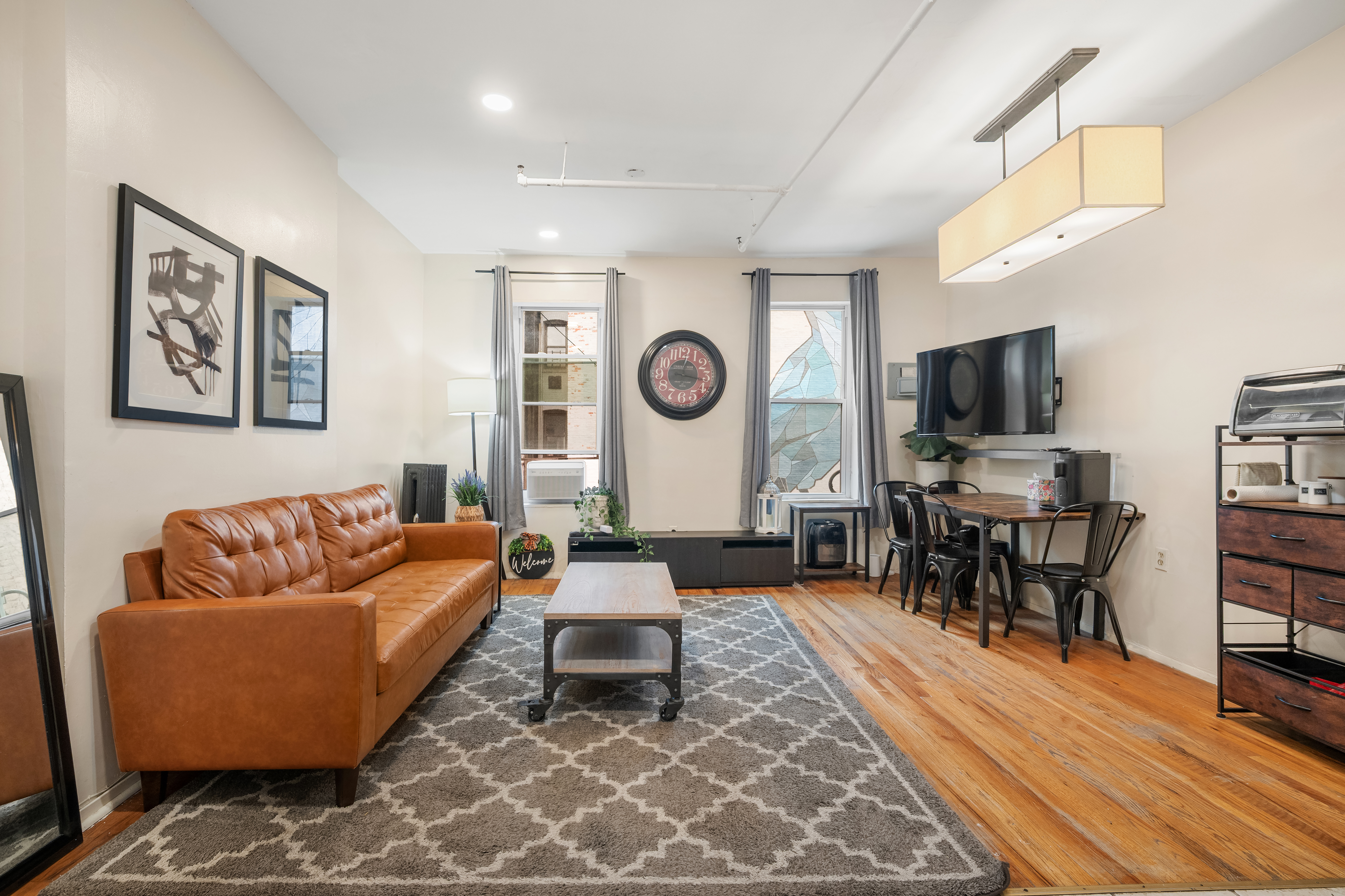 596 West 152nd Street Manhattan, NY 10031 - Photo 2 of 9 a living room with furniture and a flat screen tv