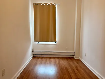 a view of a small space with wooden floor and a window