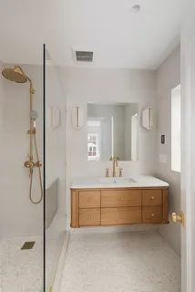 a bathroom with a granite countertop bathtub shower sink vanity and toilet
