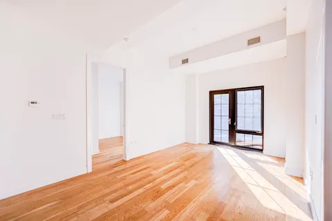a view of a livingroom with wooden floor and a window