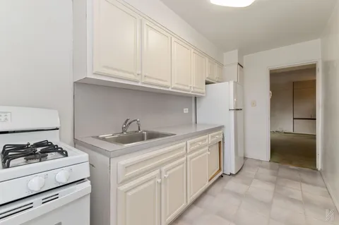 a kitchen with white cabinets and appliances