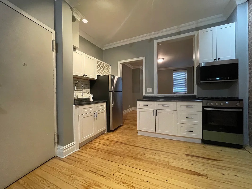 317 East 73rd Street, Unit 1RE Manhattan, NY 10021 - Photo 3 of 9 a kitchen with granite countertop a stove and a microwave