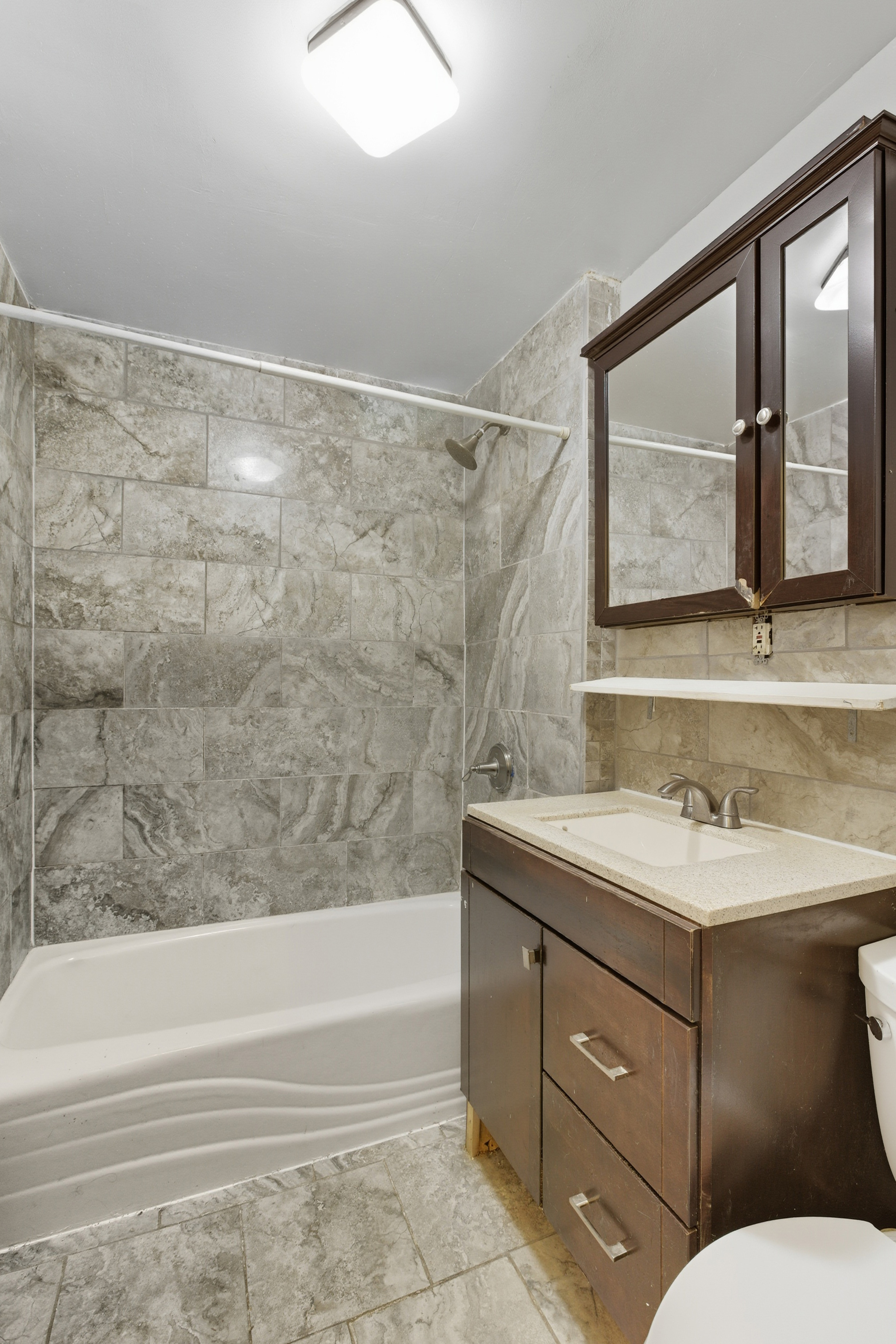 420 East 117th Street, Unit 1 Manhattan, NY 10035 - Photo 8 of 9 a bathroom with a granite countertop sink toilet and bathtub