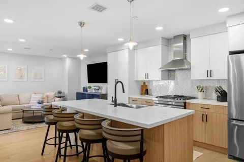 a kitchen with stainless steel appliances kitchen island granite countertop a sink and a stove