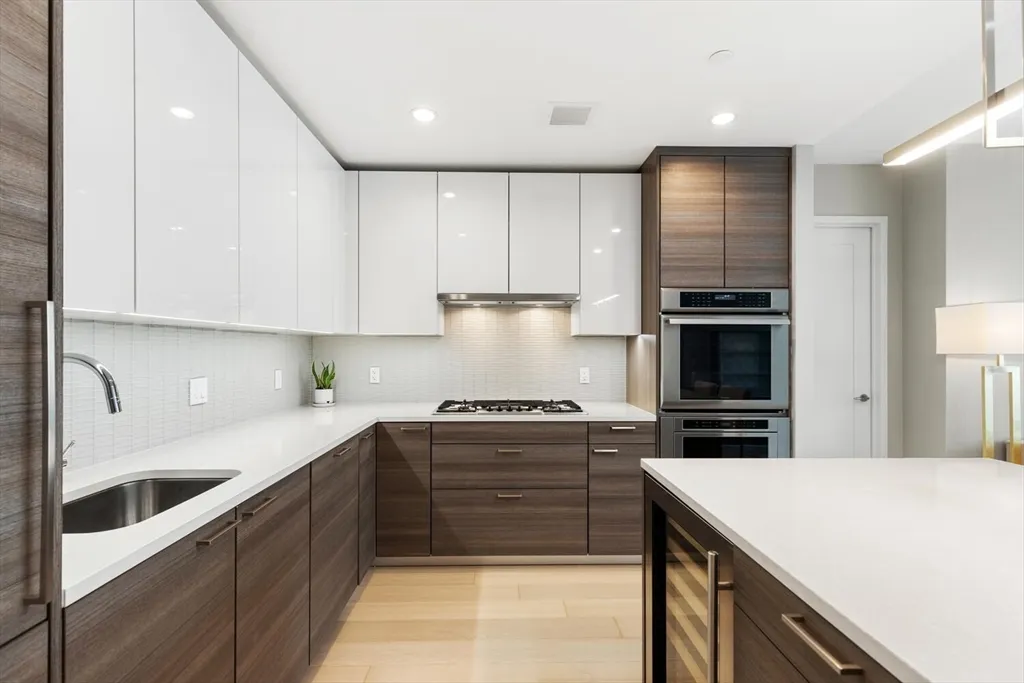 a kitchen with stainless steel appliances kitchen island granite countertop a table chairs in it and wooden floors