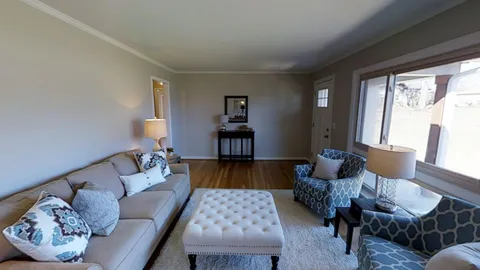 a view of a dining room with furniture a chandelier and wooden floor