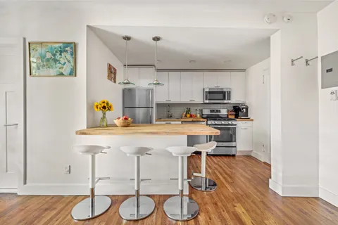 a kitchen with stainless steel appliances granite countertop a refrigerator and a stove top oven