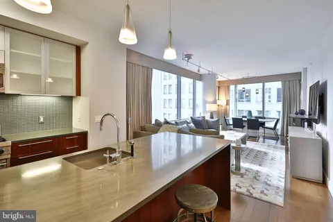 a large kitchen with kitchen island a large counter top space a sink stainless steel appliances and cabinets