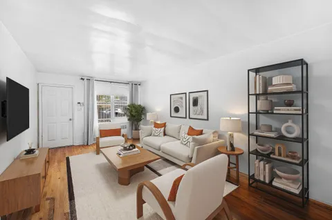 a living room with furniture a flat screen tv and kitchen view