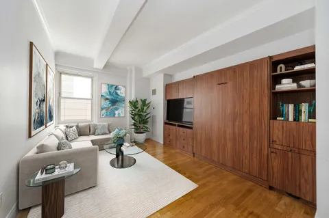 a living room with furniture a window and a flat screen tv