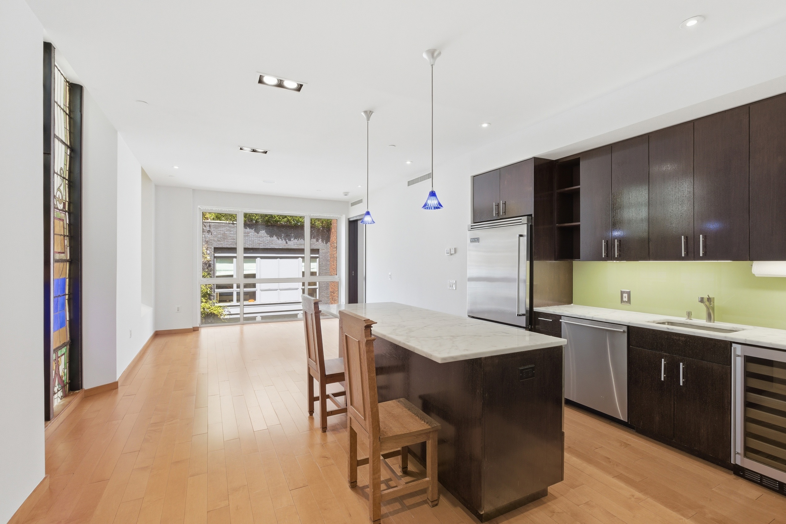 135 West 4th Street, Unit 3W Manhattan, NY 10012 - Photo 6 of 24 a kitchen with a table chairs sink and cabinets