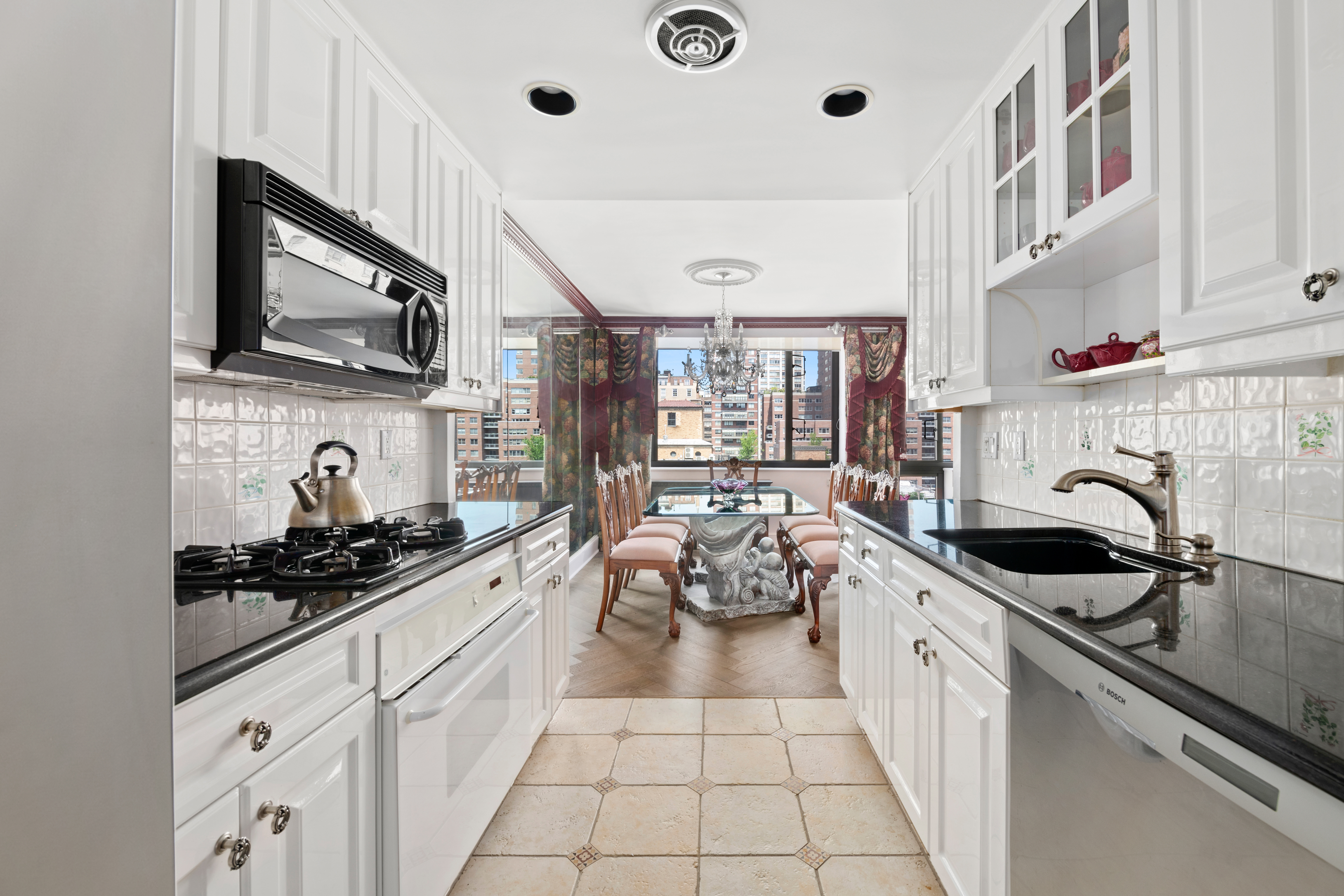 333 East 69th Street, Unit 10J Manhattan, NY 10021 - Photo 2 of 12 a kitchen with stainless steel appliances a sink stove top oven and cabinets