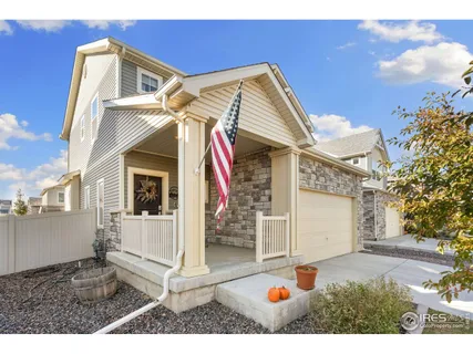 a view of a white house with a small yard and potted plants