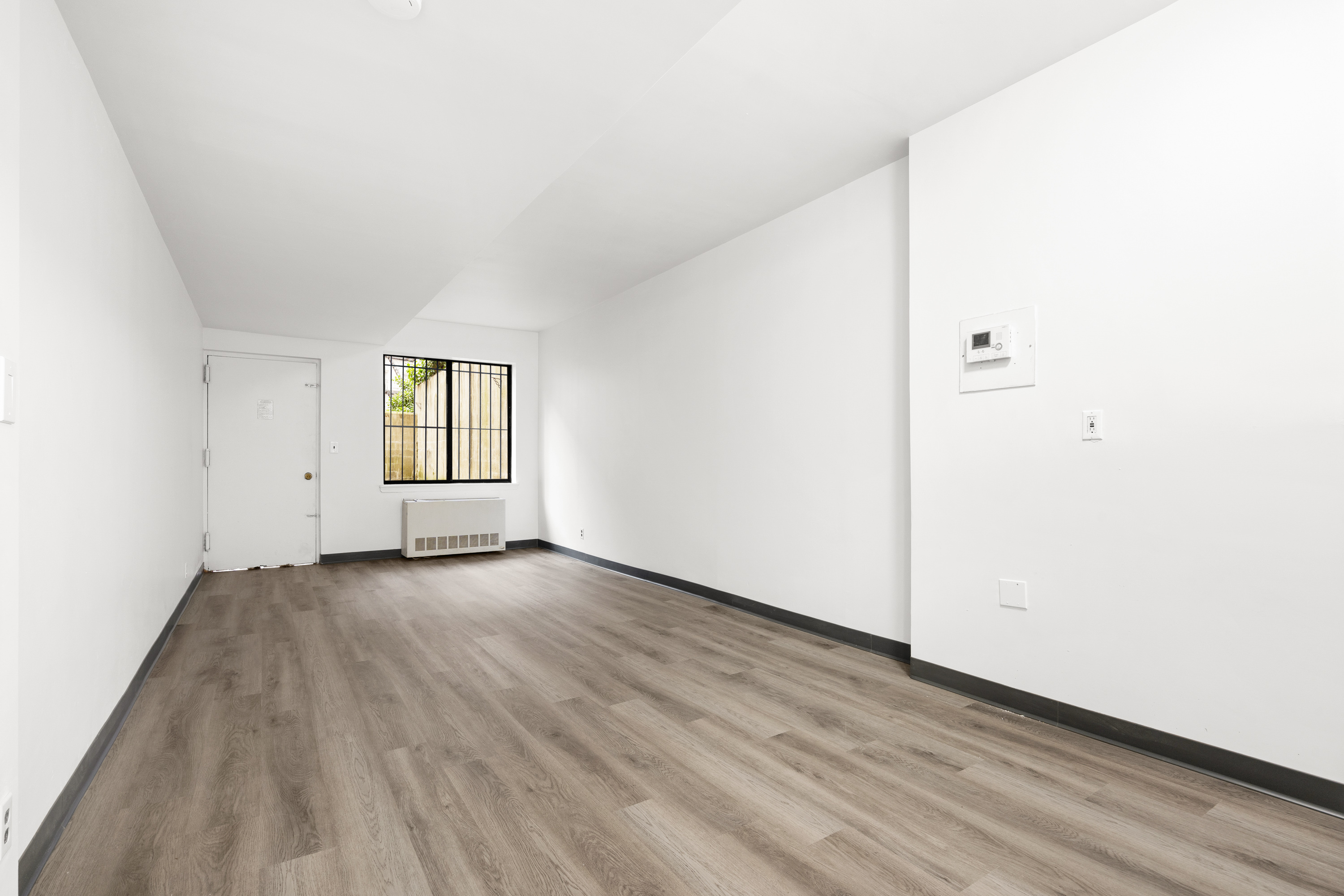 343 East 76th Street, Unit BA Manhattan, NY 10021 - Photo 1 of 5 an empty room with wooden floor and windows