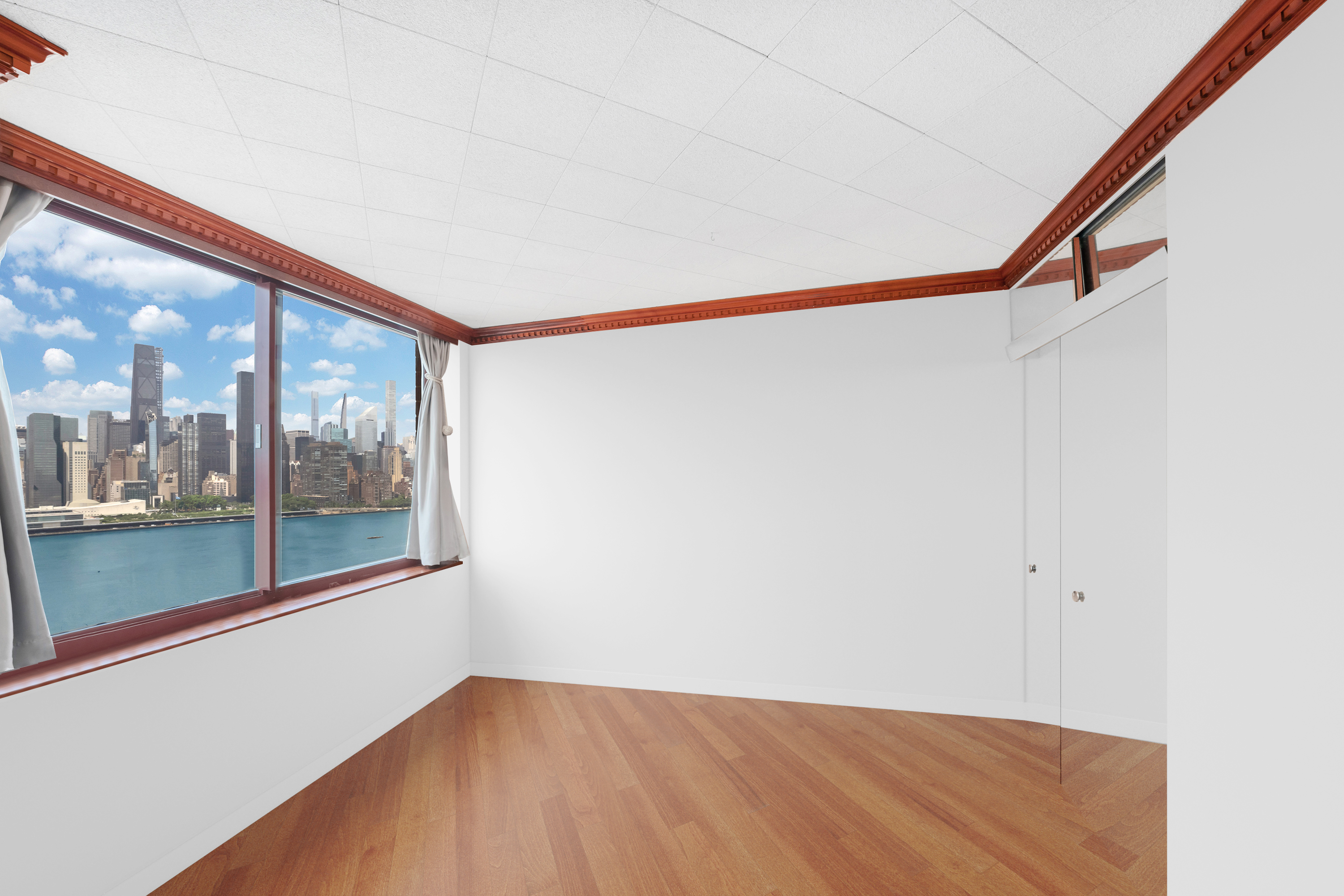 4-74 48th Avenue, Unit 27A Queens, NY 11109 - Photo 10 of 11 a view of a big room with wooden floor and windows