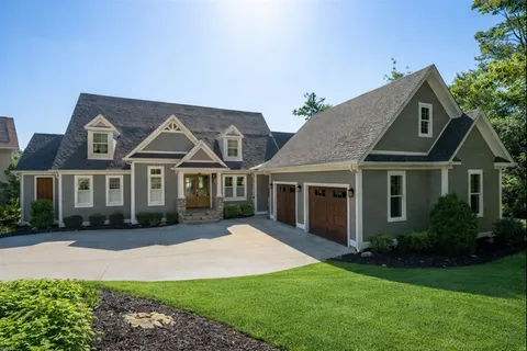 a front view of a house with a garden and yard