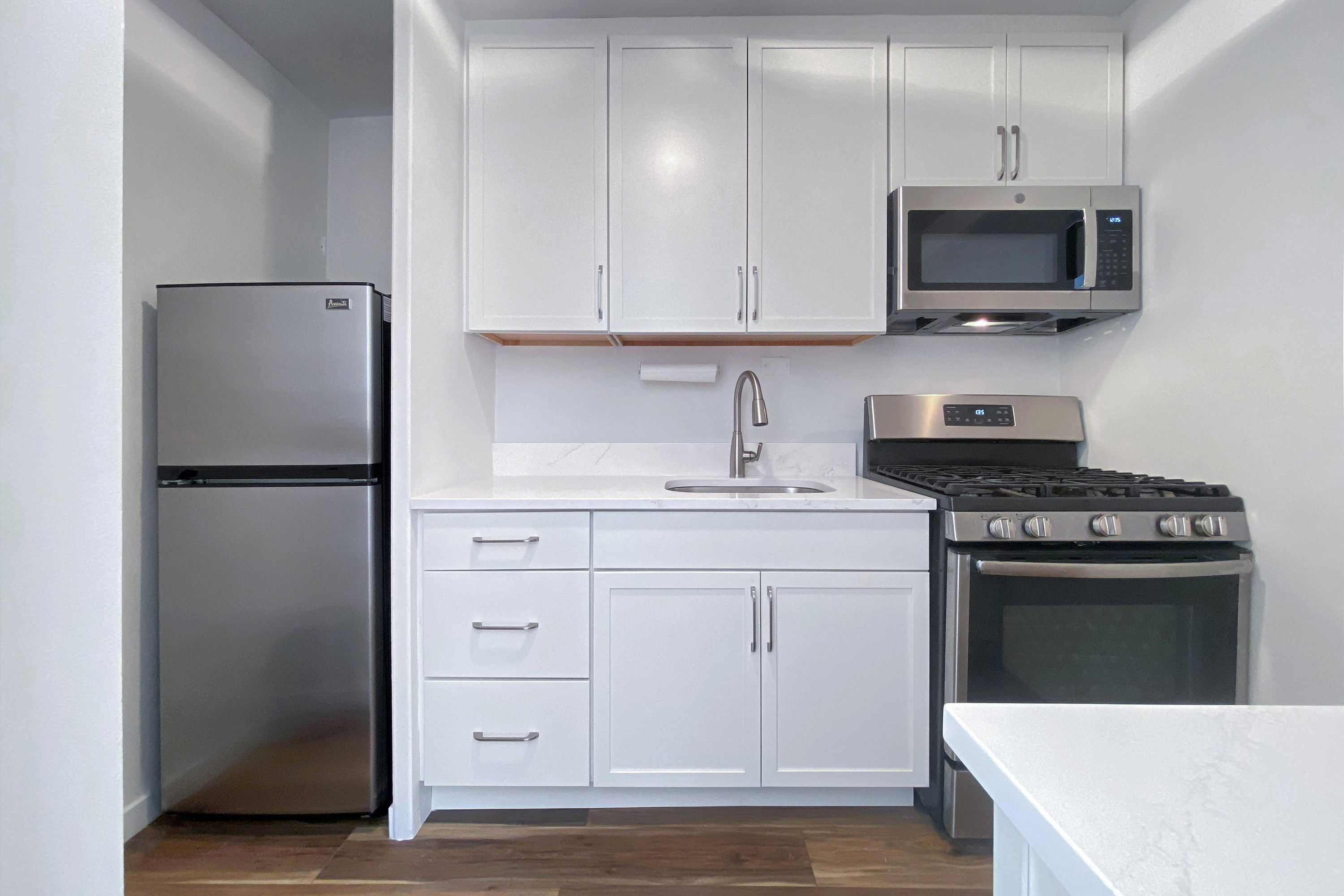 343 East 30th Street, Unit 4F Manhattan, NY 10016 - Photo 4 of 16 a kitchen with white cabinets and stainless steel appliances