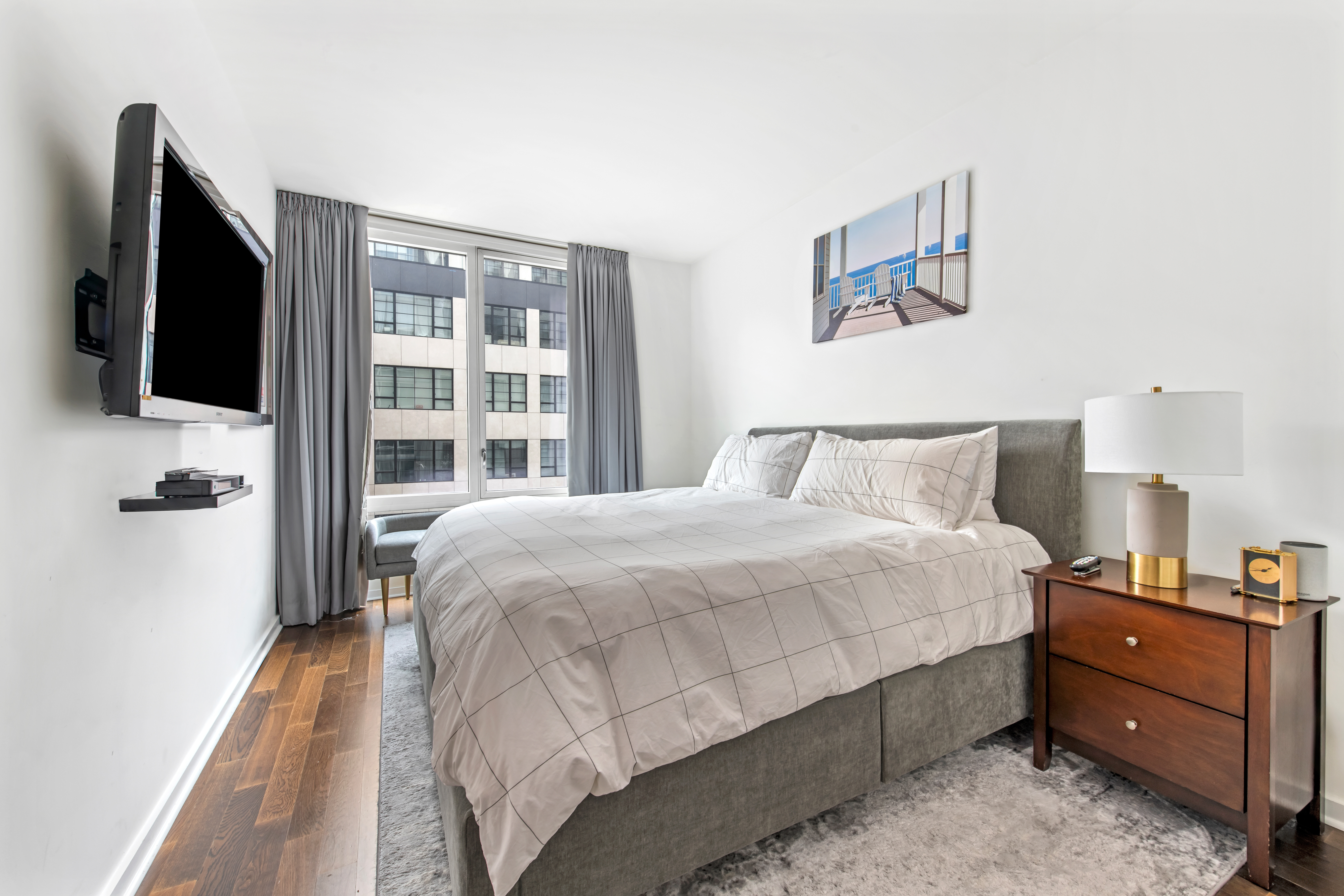 340 East 23rd Street, Unit 4D Manhattan, NY 10010 - Photo 5 of 19 a bedroom with a bed and a flat tv screen on the dresser
