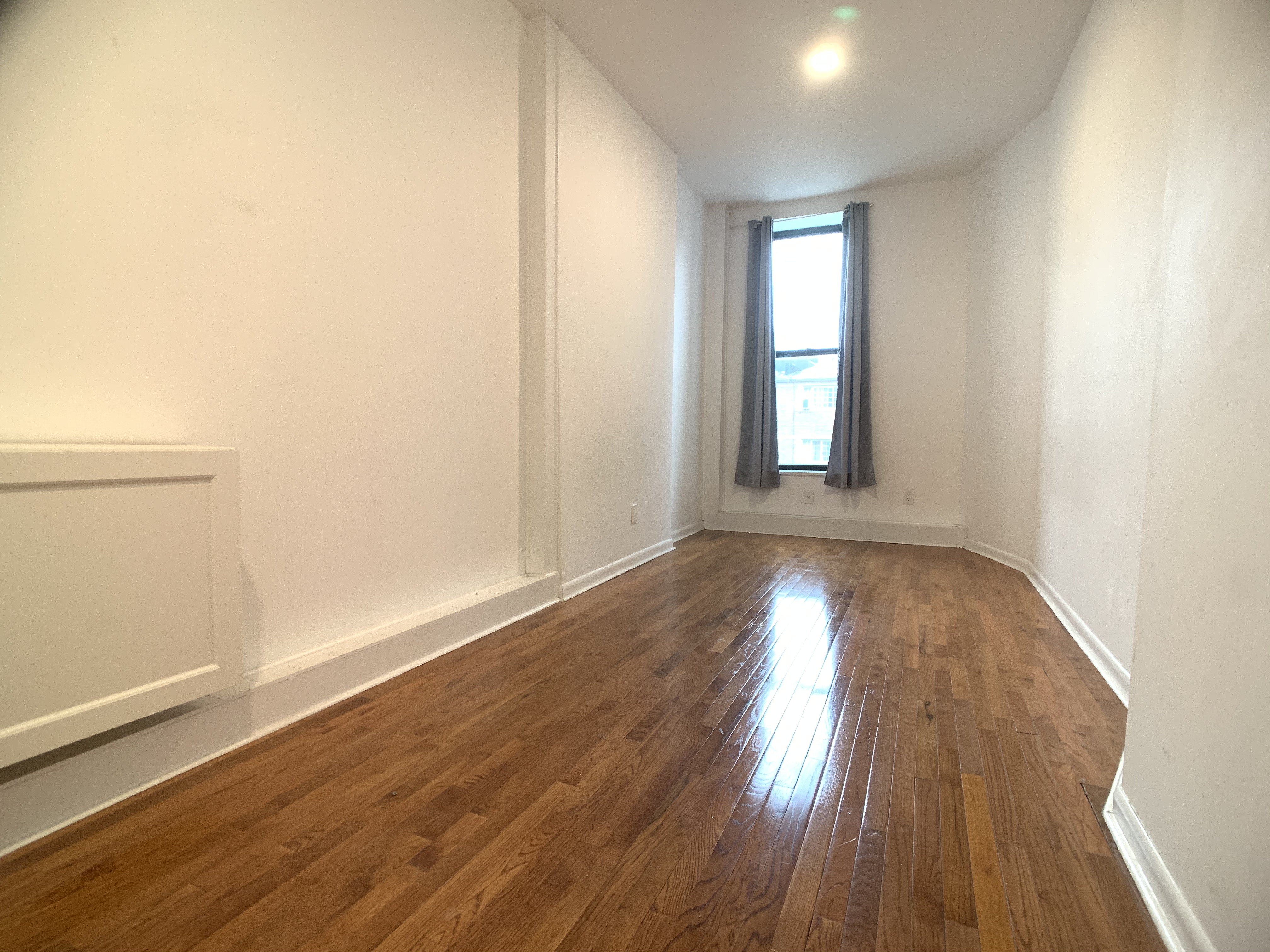 293 Tompkins Avenue Brooklyn, NY 11221 - Photo 12 of 19 an empty room with wooden floor and windows