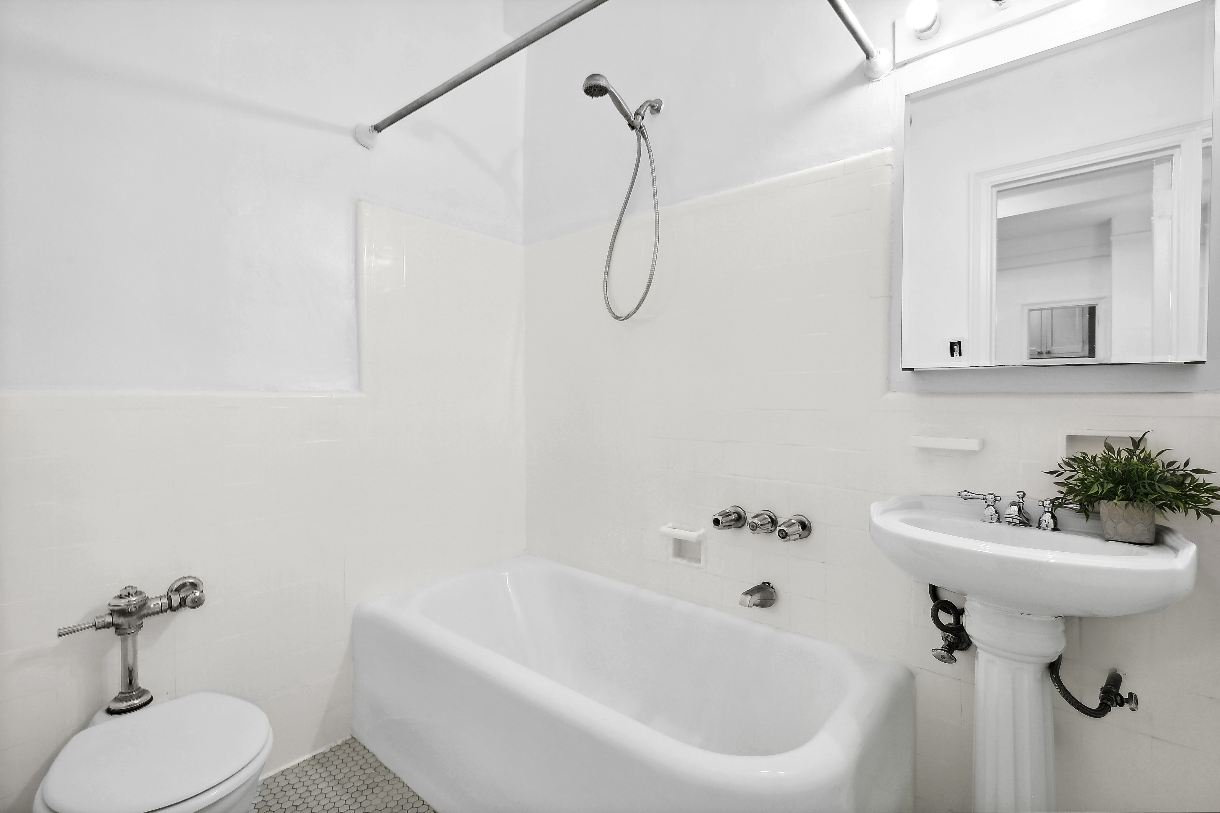 321 East 54th Street, Unit 1D Manhattan, NY 10022 - Photo 4 of 7 a bathroom with a sink a toilet and a mirror