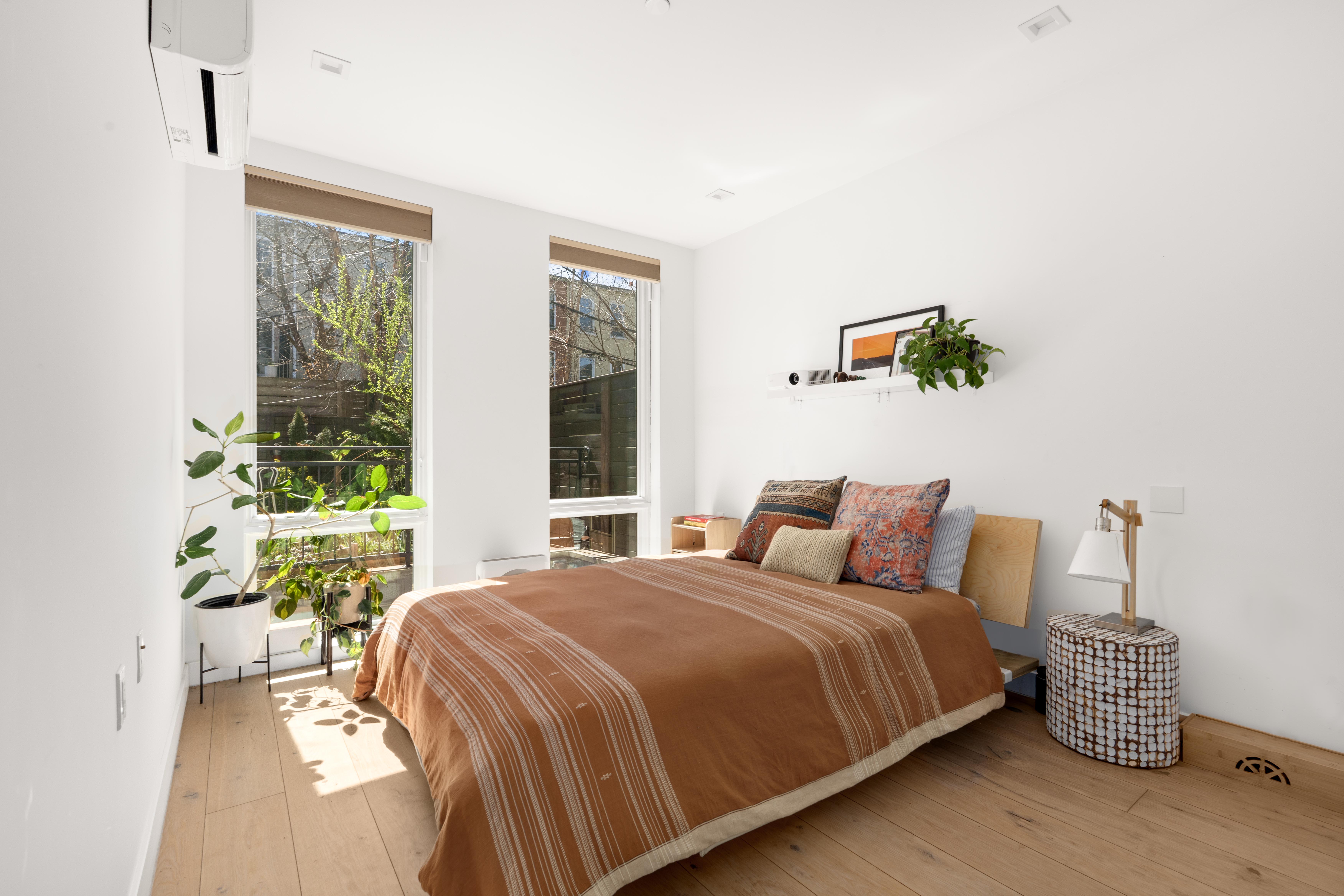 676 Halsey Street, Unit 1B Brooklyn, NY 11233 - Photo 5 of 9 a bed sitting in a bedroom next to a window