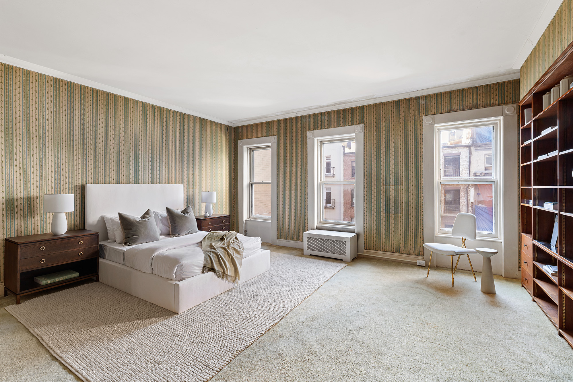10 East 82nd Street Manhattan, NY 10028 - Photo 14 of 22 a bedroom with furniture and a book shelf