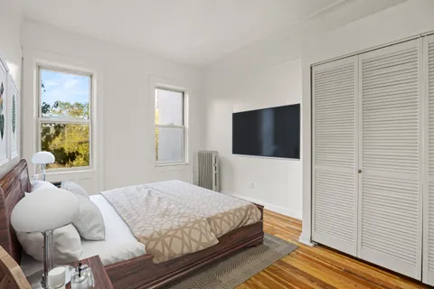 a bedroom with a bed and wooden floor
