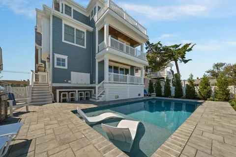 a view of a house with sitting area and couches with wooden floor and fence