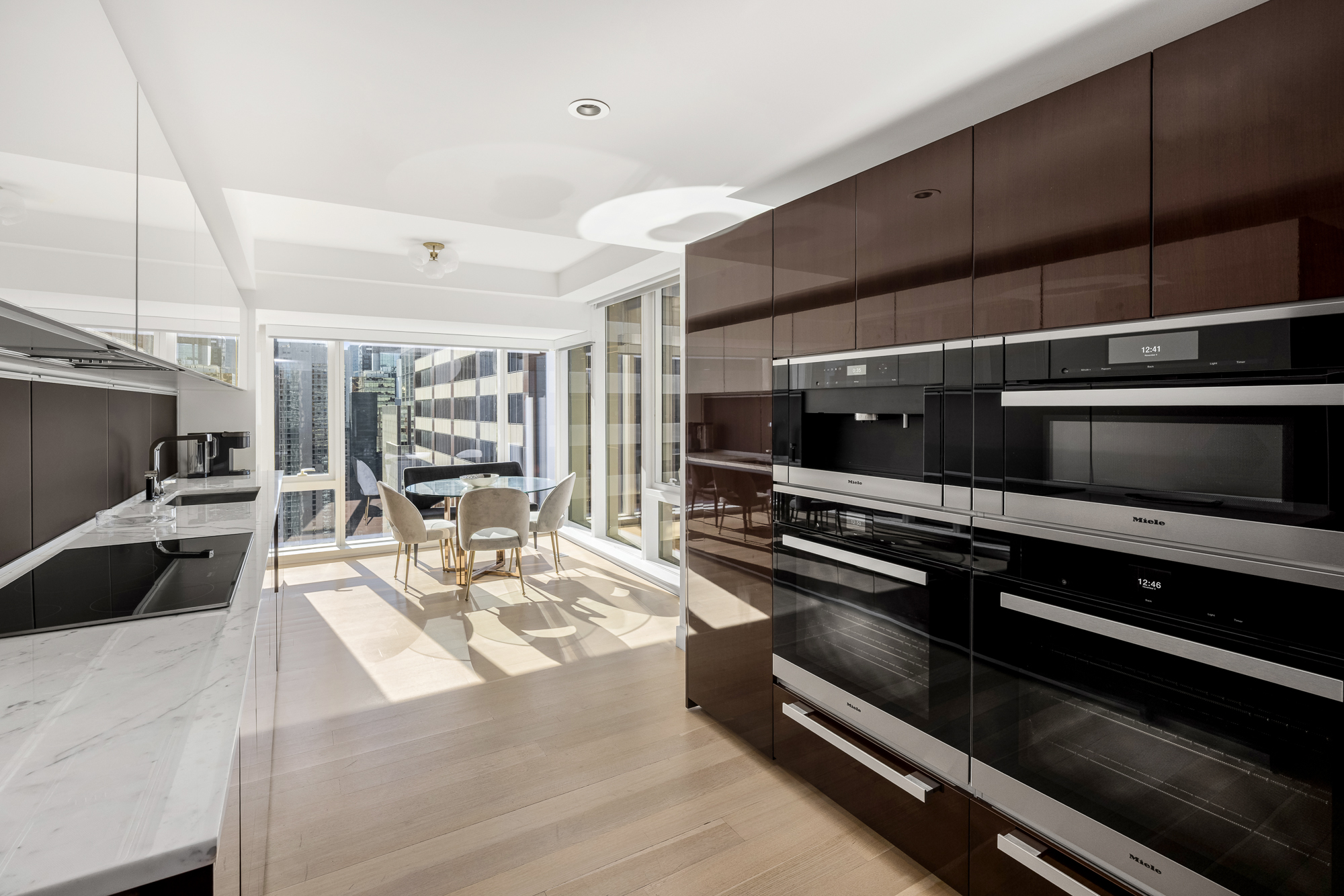 135 West 52nd Street, Unit 40A Manhattan, NY 10019 - Photo 9 of 24 a kitchen with stainless steel appliances kitchen island granite countertop a stove and a sink