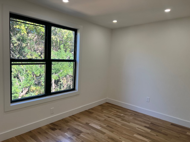 1393 Herkimer Street, Unit 2 Brooklyn, NY 11233 - Photo 5 of 9 a view of empty room with wooden floor and fan