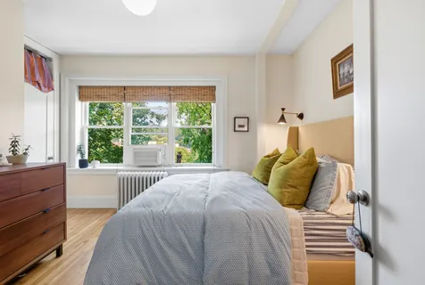a bedroom with a bed and a window