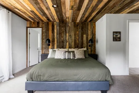 a bed sitting in a bedroom next to a window